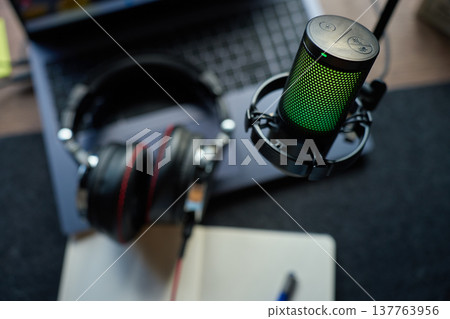 Podcast streaming desk setup with microphone laptop and headphones 137763956