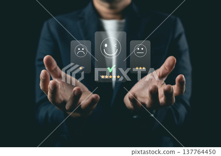 Person Evaluating Feedback with Three Different Emojis Representing Emotions in a Dark Background, Depicting User Experience and Satisfaction Levels 137764450