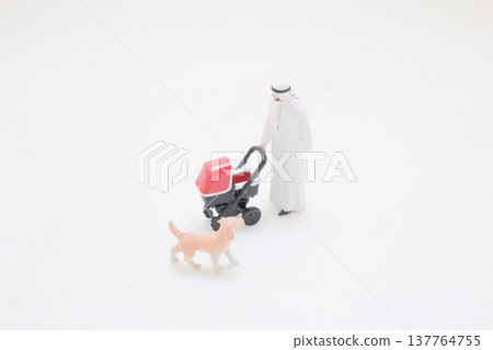 Miniature figure pushes stroller while small dog walks nearby Miniature figure pushes stroller while small dog walks nearby 137764755