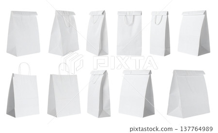 An empty white paper bag with handles lies on a white background. An empty white paper bag with handles lies on a white background. 137764989