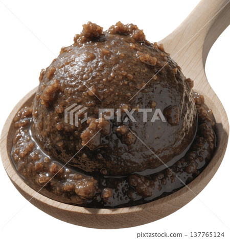 Scoop of dark brown organic fermented miso paste on wooden spoon, rich in texture and traditional flavor for cooking 137765124
