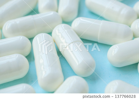 White medicine pills capsule on blue background White medicine pills capsule on blue background 137766028