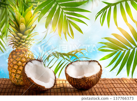 Pineapple and coconut on crystal blue pure sea or ocean background with palm tree leaves. 137766373