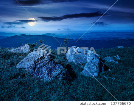 beautiful summer mountain landscape at night. full moon over huge boulders among the grass on the edge of hill. alpine scenery with clouds on the sky. view in to the valley from high altitude beautiful summer mountain landscape at night. full moon over huge boulders among the grass on the edge of hill. alpine scenery with clouds on the sky. view in to the valley from high altitude 137766670