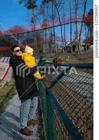 Father holding toddler at petting zoo enclosure Father holding toddler at petting zoo enclosure 137766907