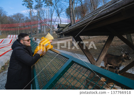 Father holding toddler at petting zoo enclosure Father holding toddler at petting zoo enclosure 137766918