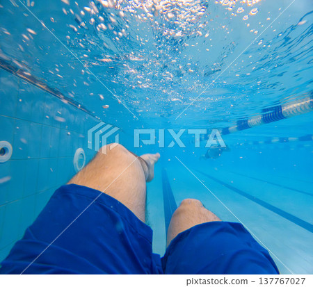 Underwater pov of swimmer legs in blue pool Underwater pov of swimmer legs in blue pool 137767027