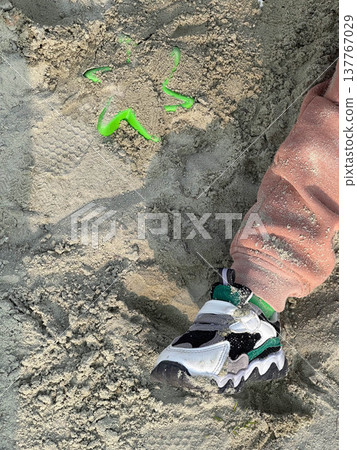 Child sneaker in beach sand with toy shovel Child sneaker in beach sand with toy shovel 137767029