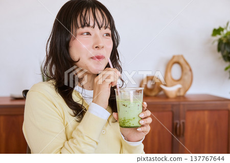 一位年輕女性的健康生活方式包括喝抹茶拿鐵 137767644