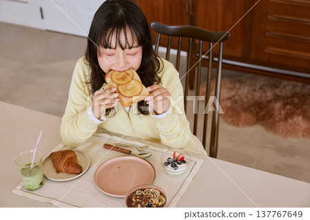 A woman's lifestyle overview: eating a healthy breakfast of toast A woman's lifestyle overview: eating a healthy breakfast of toast 137767649