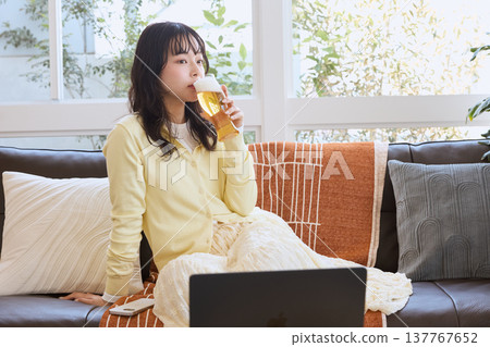一位年輕女子在家享用啤酒 137767652