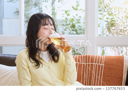 一位女性在休閒時間喝啤酒的生活方式 一位女性在休閒時間喝啤酒的生活方式 137767653