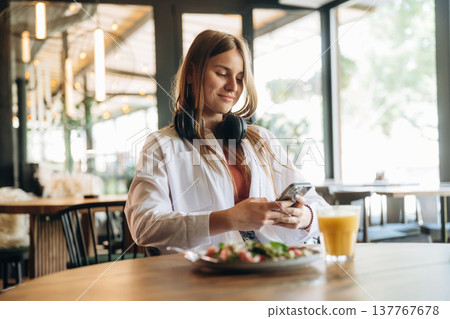 Chilling and sitting. Young woman is in the cafe at daytime Chilling and sitting. Young woman is in the cafe at daytime 137767678