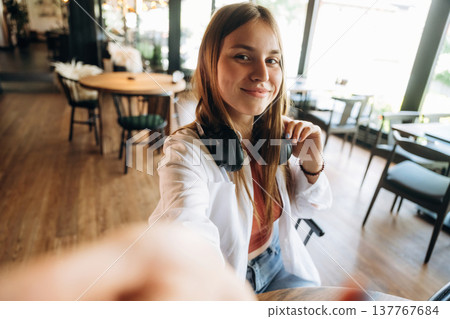 Making a selfie. Young woman is in the cafe at daytime Making a selfie. Young woman is in the cafe at daytime 137767684