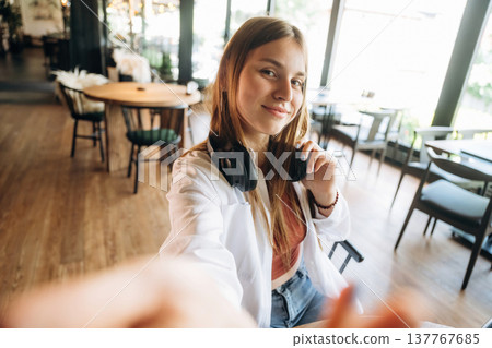 Making a selfie. Young woman is in the cafe at daytime Making a selfie. Young woman is in the cafe at daytime 137767685