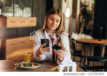 Young woman is in the cafe at daytime Young woman is in the cafe at daytime 137767697