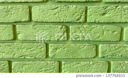 Vibrant lime green painted brick wall texture providing a bold industrial background for design 137768033