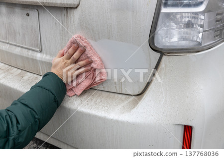 I'm wiping the dirty car body with a damp cloth. 137768036