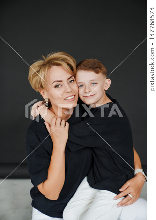 Mother and son pose together in a studio setting 137768573
