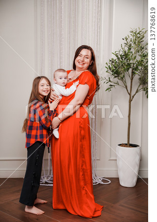 Family portrait with mother and two children in a home setting Family portrait with mother and two children in a home setting 137768619