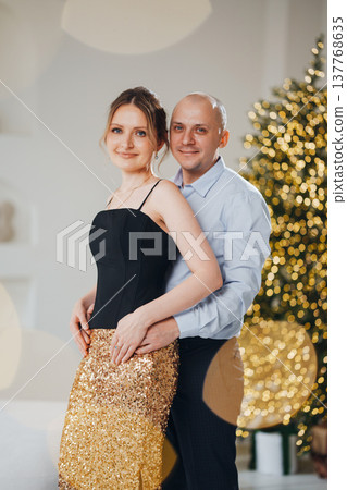 Couple posing together at a festive gathering with decorations 137768635