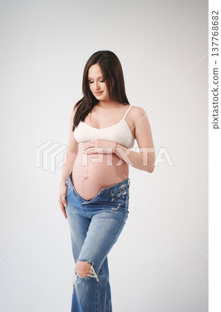 Expecting mother showing off her baby bump in casual style 137768682