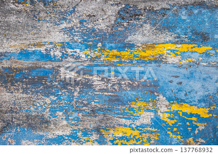 Peeling paint on the concrete wall with old cracked flaking paint. Weathered rough painted surface 137768932