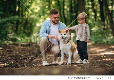 Father with son and dog are in the forest 137769255