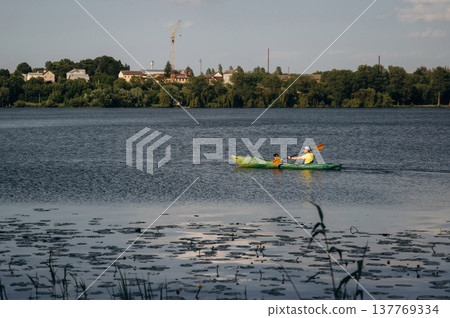 Sportive father is with his young son is swimming in the kayak Sportive father is with his young son is swimming in the kayak 137769334