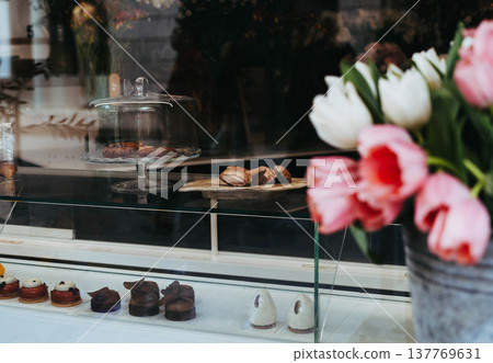 Elegant bakery display with pastries and desserts behind a glass counter, Elegant bakery display with pastries and desserts behind a glass counter, 137769631