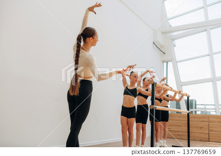 Daily practice routine. Trainer is teaching girls ballet dancing Daily practice routine. Trainer is teaching girls ballet dancing 137769659