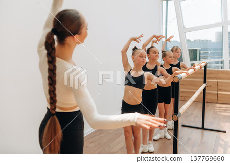 Trainer is teaching girls ballet dancing Trainer is teaching girls ballet dancing 137769660