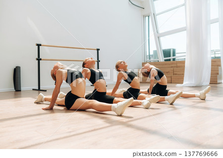 On the floor. Girls practicing ballet indoors in the class 137769666