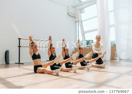 Daily practice routine. Trainer is teaching girls ballet dancing 137769667