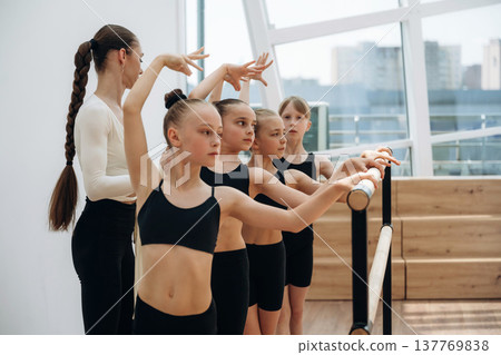 Controlling the process. Trainer is teaching girls ballet dancing Controlling the process. Trainer is teaching girls ballet dancing 137769838