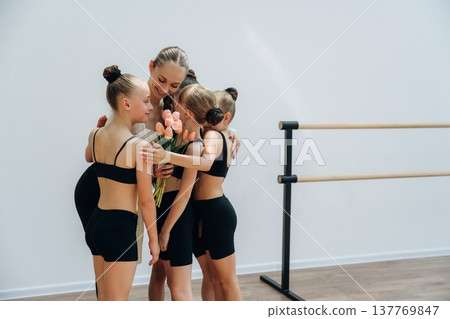 Gifting the flowers. Trainer is teaching girls ballet dancing Gifting the flowers. Trainer is teaching girls ballet dancing 137769847