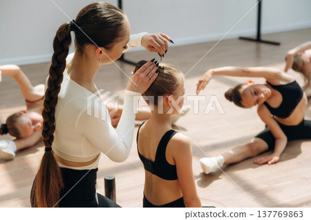 Taking care of hair. Trainer is teaching girls ballet dancing 137769863