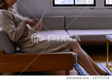 A woman using a tablet in the living room 137771319