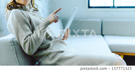 The woman's hands and knees pointing at the tablet. The woman's hands and knees pointing at the tablet. 137771325