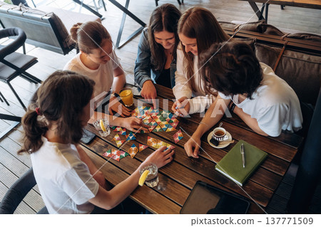 View from the top, playing game. Group of young friends are in the cafe restaurant View from the top, playing game. Group of young friends are in the cafe restaurant 137771509