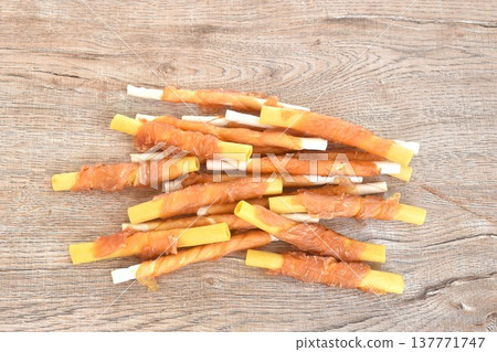 dog snack crunchy stick made from cow leather and bone wrapped chicken meat on table dog snack crunchy stick made from cow leather and bone wrapped chicken meat on table 137771747