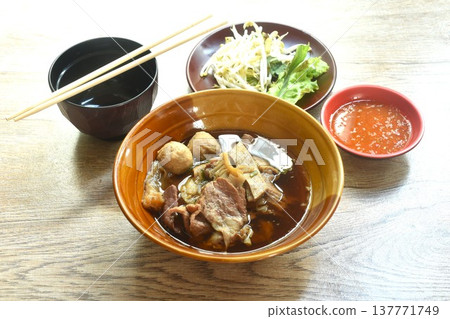 boiled braised beef meat and tendon couple organ in herb brown soup on bowl dipping spicy chili sauce 137771749