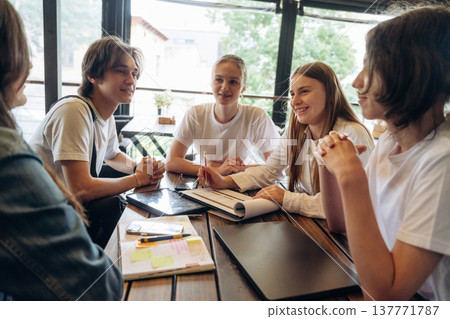 Job with documents in progress, start up. Group of young friends are in the cafe restaurant Job with documents in progress, start up. Group of young friends are in the cafe restaurant 137771787