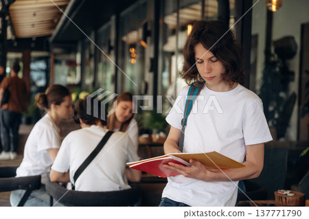 Standing in front of people. Group of young friends are in the cafe restaurant Standing in front of people. Group of young friends are in the cafe restaurant 137771790