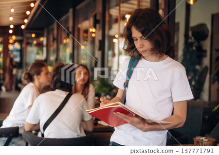 Standing in front of people. Group of young friends are in the cafe restaurant Standing in front of people. Group of young friends are in the cafe restaurant 137771791