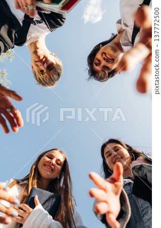 View from below of young friends against the sky View from below of young friends against the sky 137772500