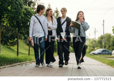 On the cobblestones, having a walk. Friends students are together outdoors On the cobblestones, having a walk. Friends students are together outdoors 137772523