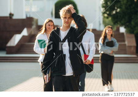 At sunny day, standing. Group of students are near university together At sunny day, standing. Group of students are near university together 137772537