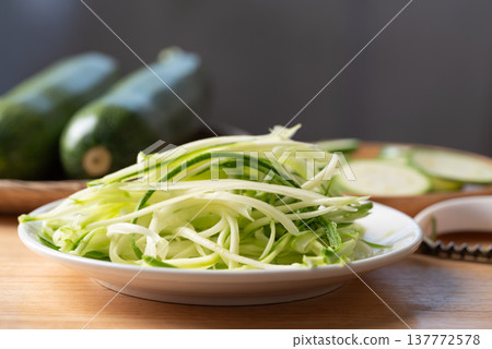 Fresh zucchini noodles (zoodles) in a white plate, prepared for healthy cooking Fresh zucchini noodles (zoodles) in a white plate, prepared for healthy cooking 137772578