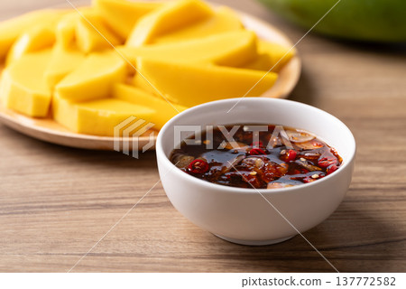 Fresh sliced mangoes eating with Thai sweet fish sauce (Nam Pla Wan) Fresh sliced mangoes eating with Thai sweet fish sauce (Nam Pla Wan) 137772582